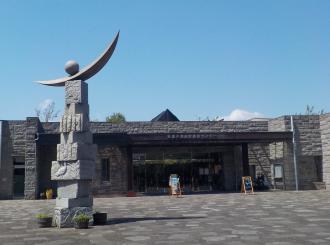 左手前に石造りのモニュメントが設置されている谷津干潟自然観察センターの建物外観の写真