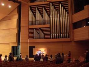 間近でパイプオルガンの演奏を聞いている習志野文化ホール内の写真
