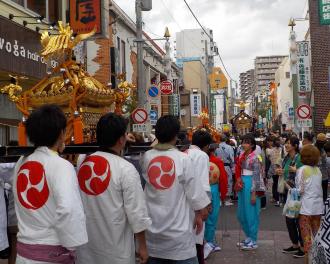 法被を着た男性たちが神輿を担いでいる誉田八幡神社の例祭の様子の写真
