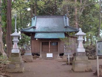 木々に囲まれ両側手前に石灯篭や狛犬が設置されている諏訪神社の境内の写真