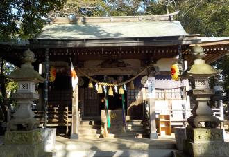 手前左右に設置された石灯篭の奥に鎮座する誉田八幡神社の拝殿の写真
