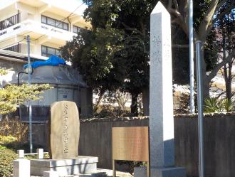 校舎の手前に設置された騎兵第13連隊記念の説明看板と石碑の写真