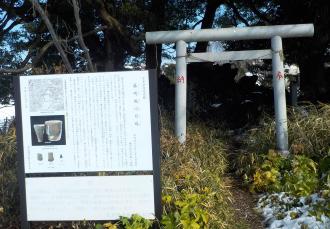 後方に木々が立ち並んでいる右手前に鳥居、左手前に説明板が設置されている藤崎堀込貝塚の写真