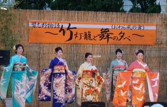 竹灯籠と舞の夕べのステージイベントで色とりどりの着物を着た5名の女性が横一列に並んでいる写真