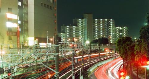 JR津田沼駅付近で撮影された電車と車の露光写真