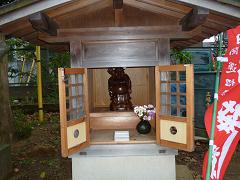 両扉が開かれた布袋尊像が祭られている正福寺境内に設置された小さな祠の写真