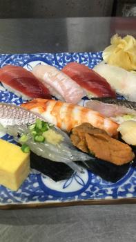 青色の皿の上に11種類のにぎり寿司が並んでいる写真