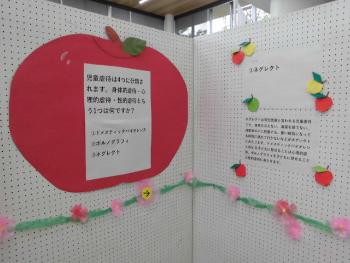 白い用紙や赤いリンゴの背景に児童虐待防止クイズが書かれている写真