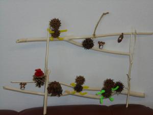 まつぼっくりやドングリなどの木の実と枝とモールで作ったオブジェの写真