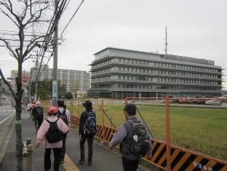 市役所の建物に向かって道路沿いの道を歩いている参加者の写真