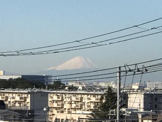 団地の建物の奥に見える富士山の写真