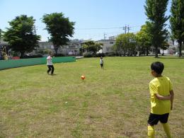 子ども二人と芝生でサッカーをしている志摩豊さんの写真