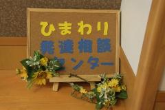 ヒマワリの花でデコレーションされた「ひまわり発達相談センター」と書かれたボードの写真