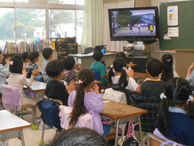 教室で動画を見ながら拍手をする1年生