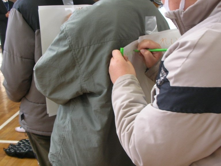 背中にメッセージを書く様子