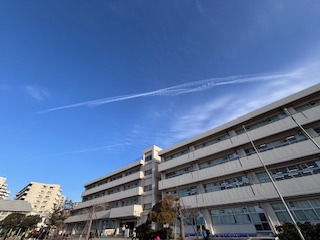 校舎の上空に延びていく飛行機雲