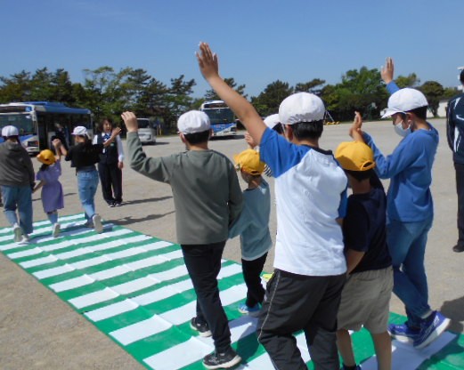 5年生と手をつないで模擬横断歩道を歩く様子