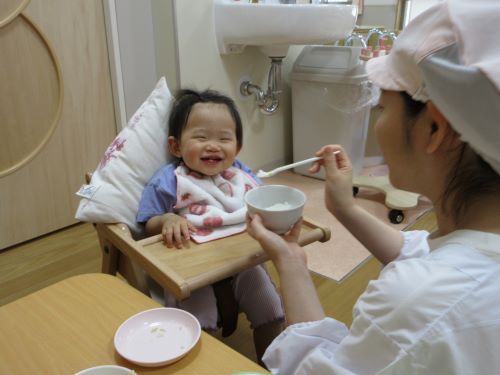 笑顔で食事をする0歳児