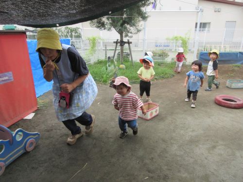 1歳児が保育者と一緒によーいどん！と走っているところ