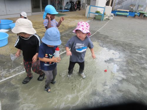 2歳児が泥水の中で足踏みして感触を楽しんでいるところ