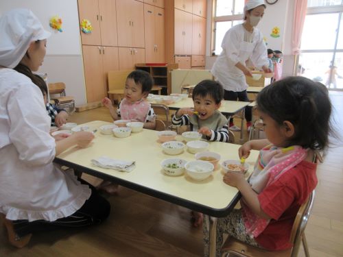 自分でスプーンを持って食べる2歳児