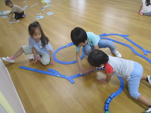 5歳児と3歳児が一緒にプラレールで遊んでいる所