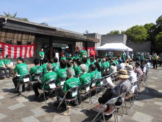 「谷津干潟の日」宣言20周年の式典でパイプ椅子に沢山の緑のジャケットを着た人たちが座っている写真