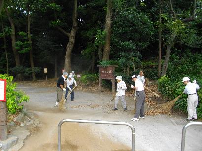 あかしあ会の方々が車止めの近くで清掃作業を行っている様子の写真