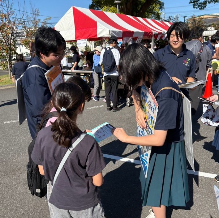 高校生が子供にシールを配布している様子