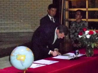 調印式で協定書にサインをしているマドックス市長の写真