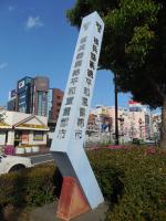 垣根前に「核兵器廃絶平和宣言都市」の文字塔が建っているJR津田沼駅南口広場の写真
