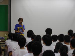 多くの中学生の前に立ち、マイクを持って話をしている小野さんの写真
