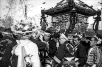 神輿を担いでいる多くの人々をアップで写した白黒写真