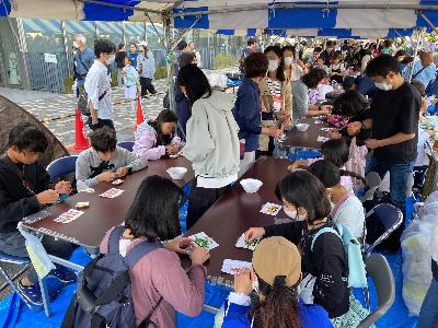 帽子を被った男の子が円盤投げの遊びをしている子ども広場の写真