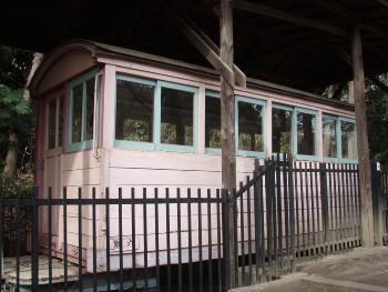 木製で窓が付いた薄いピンク色のB型客車の写真