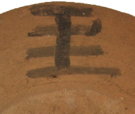 王の文字に横棒が一本多い文字が入った土器の写真