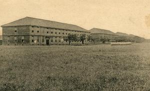 前方に広い草原が広がり、兵舎がある白黒写真