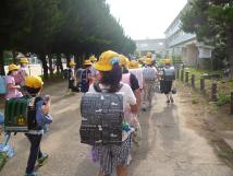 黄色帽子を被り、ランドセルを背負った子供たちを後方から写した写真