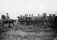 馬に乗って移動している騎兵隊の人々の白黒写真