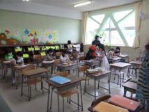 教室の自席に座っている子供たちが、机上に広げた教科書などを見ている様子の写真