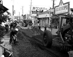 商店街通りの舗装工事を行っている白黒写真