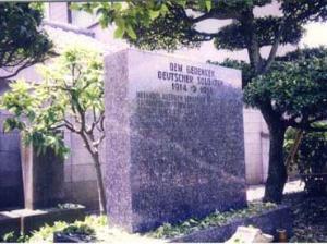 英語で文字が刻まれたドイツ墓地のオルガン型の墓石の写真