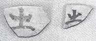 「出」の文字が薄墨で書かれた土器の破片の写真