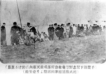 テントの前に立っている大勢の捕虜たちの白黒写真
