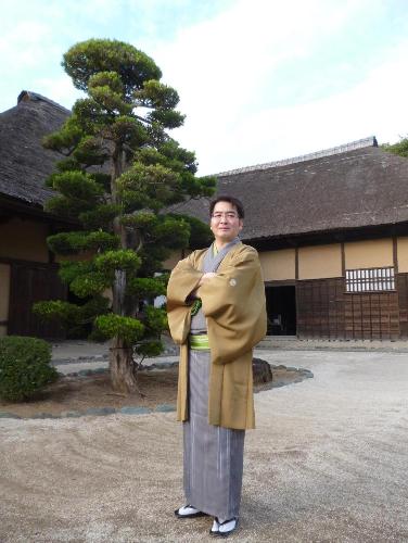 旧鴇田家住宅を背景にした月の家小圓鏡師匠