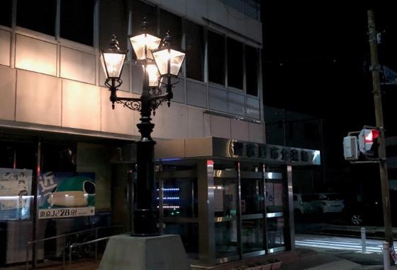 企業局前に設置されている4灯式のガス灯が真っ暗な夜道をやさしく照らしている写真