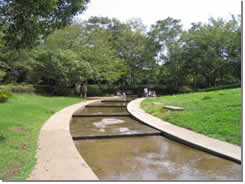 芝生の間に浅い水路がある香澄公園の写真