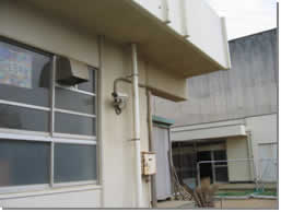 校舎建物の軒下に設置された防犯カメラの写真