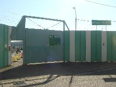 緑と白のフェンスの入り口から奥の袖ケ浦自転車等保管場所が見える写真