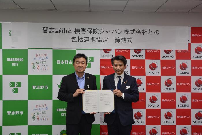 協定書を披露する宮本市長（左）と米本千葉西支店長